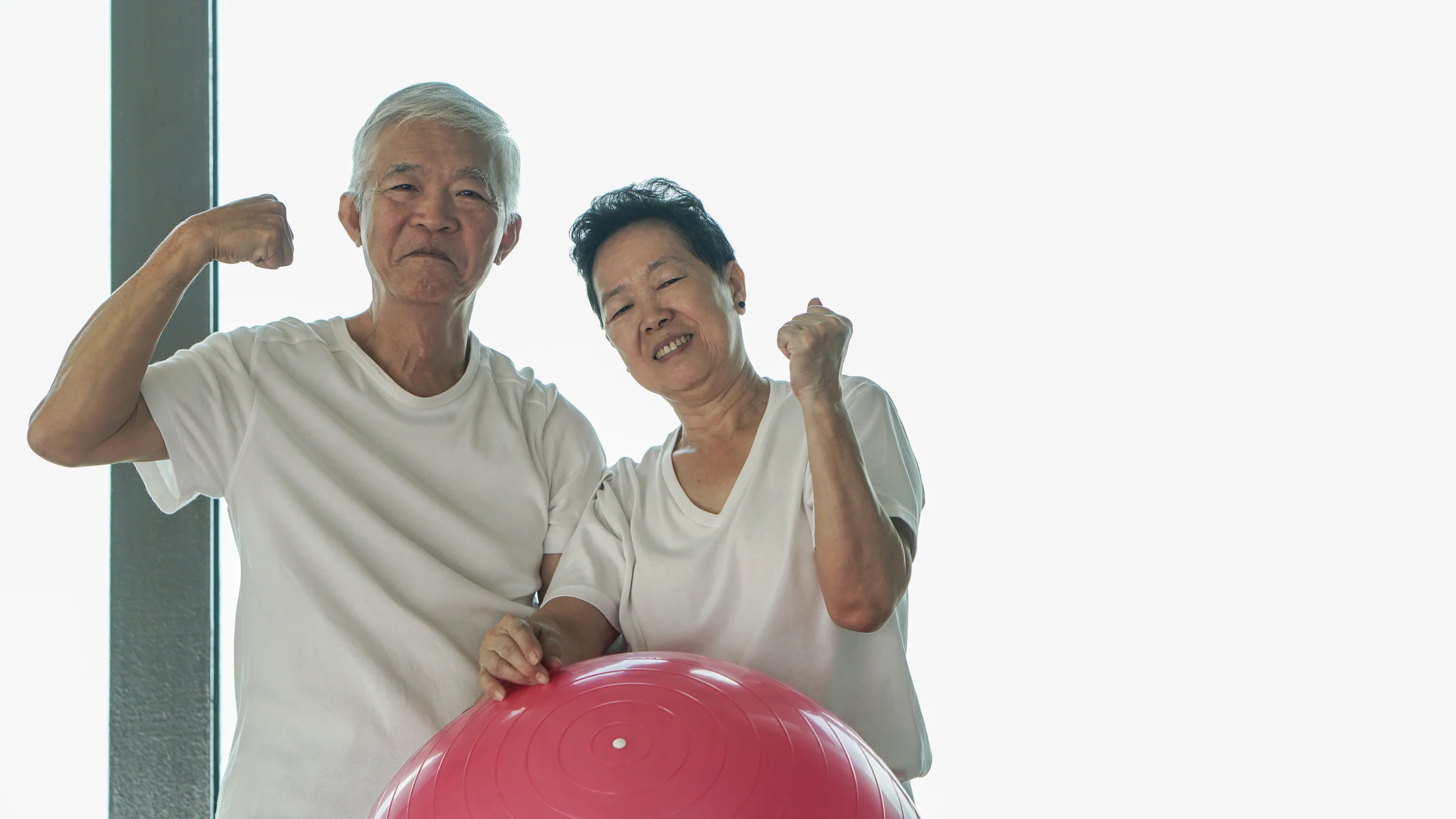 Strong Elderly Couple Exercising with Gym Ball